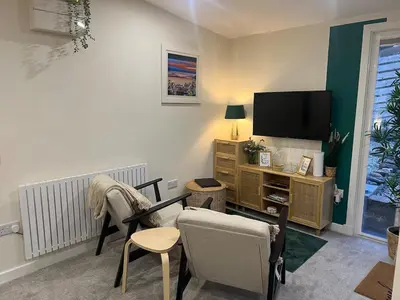 a living room with two chairs and a television at The Wee Bank Hut in Oban