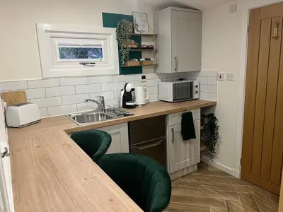 a kitchen with a sink and a counter with a microwave at The Wee Bank Hut in Oban