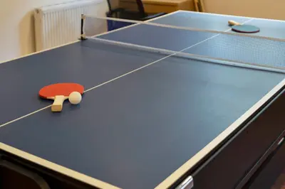 a ping pong table with a red paddle on it at The Clydesider in Glasgow