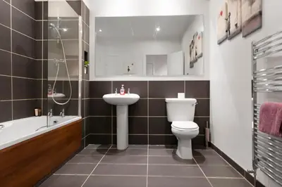 a bathroom with a sink and a toilet and a bath tub at The Clydesider in Glasgow