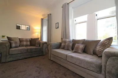 a living room with two couches and a window at Modern 2 Bedroom Cottage Flat in Stenhousemuir