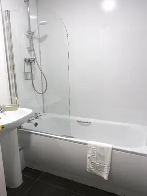 a white bathroom with a tub and a sink at Bright 3 Bed Apt overlooking the Clyde SEC & Hydro in Glasgow