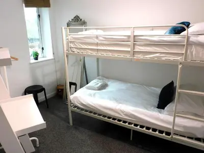 a room with two bunk beds with a black cat on them at Bright 3 Bed Apt overlooking the Clyde SEC & Hydro in Glasgow