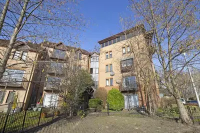 an apartment building with a fence in front of it at Bright 3 Bed Apt overlooking the Clyde SEC & Hydro in Glasgow