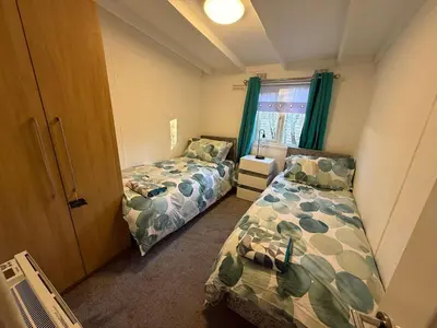 a bedroom with two beds and a window at Bethany Woodland Lodge in Winchburgh