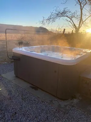 a bath tub sitting on the ground with the sunset at Bethany Woodland Lodge in Winchburgh