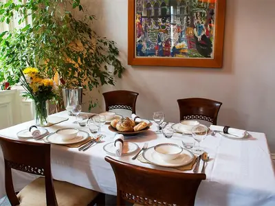 a table with a white tablecloth and chairs with a plate of food at West George Street Apartment Glasgow in Glasgow