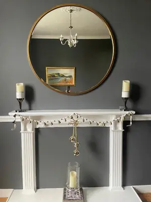 a mirror above a white console table with a candle at Hidden Gem in Stirling