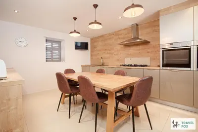 a kitchen with a wooden table and chairs at Charlotte Street Stay in Port Ellen