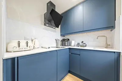a kitchen with blue cabinets and a sink at O Hill Crescent 1 Bedroom Studio - Edinburgh in Edinburgh