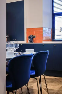 a kitchen with a table and blue chairs at No 4 Burnbank in Oban