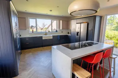 a kitchen with a large island with red bar stools at Scottish White House in Edinburgh