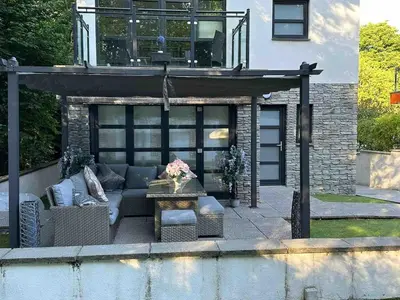 a patio with a couch and a table and a building at The Loch Lomond Townhouse In The Centre of Balloch in Balloch