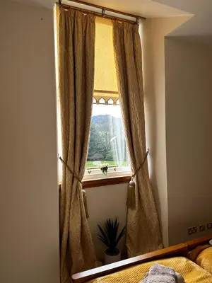 a bedroom with a window with a curtain at 6 Lomond Castle - The Inchcruin Suite in Luss