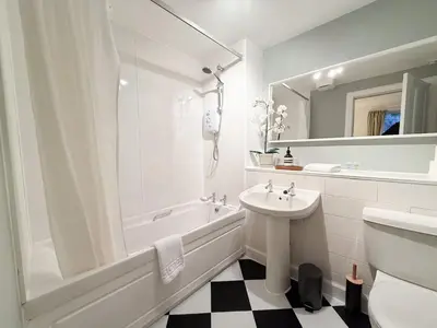 a white bathroom with a sink and a tub and a toilet at Blantyre Cosy Hideaway in Edinburgh