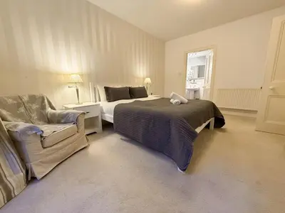 a bedroom with a bed and a couch and a chair at Blantyre Cosy Hideaway in Edinburgh