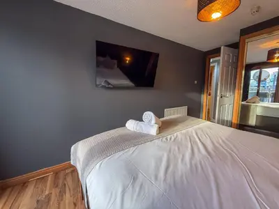 a bedroom with a bed with towels on it at Riverside 1bd - Balcony & Parking Hydro SECC in Glasgow