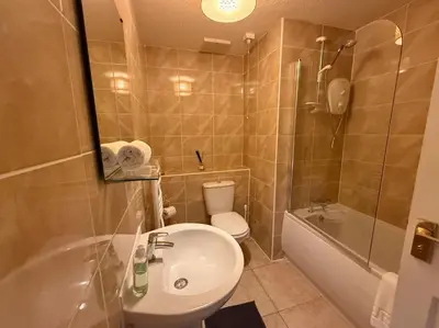 a bathroom with a sink and a toilet and a tub at Riverside 1bd - Balcony & Parking Hydro SECC in Glasgow