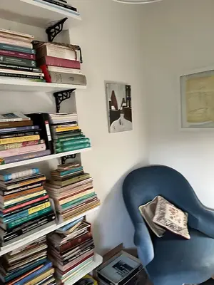 a blue chair sitting next to a stack of books at Deal - The place to stay in Moffat