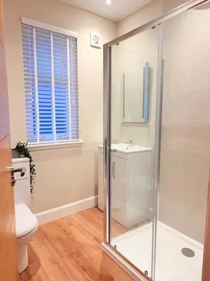 a bathroom with a shower and a toilet and a sink at Bright and spacious 2 bedroom flat in Auchterarder