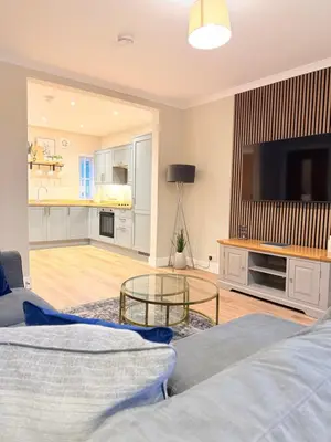 a living room with a flat screen tv and a couch at Bright and spacious 2 bedroom flat in Auchterarder