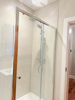 a shower with a glass door in a bathroom at Bright and spacious 2 bedroom flat in Auchterarder