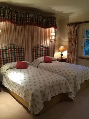 a bedroom with two beds and a window at Melfort House in Kilmelford