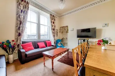 a living room with a couch and a table at Edinburgh Central Morrison Roomz in Edinburgh
