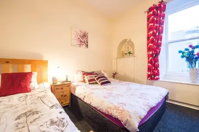a bedroom with two beds and a window at Edinburgh Central Morrison Roomz in Edinburgh