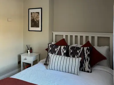 a bedroom with a bed with red and white pillows at Riverview House in Minnigaff