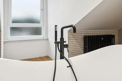 a black radiator in a room with a window at Spacious 5 Bedroom Home With 3 Bathrooms And Private Parking in Glasgow