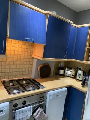 a kitchen with blue cabinets and a stove top oven at Crouch End in Moffat