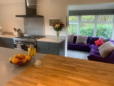 a kitchen and living room with purple furniture at Spacious, bright home in Central Scotland sleeps 6 in Balfron