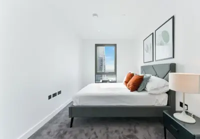 a white bedroom with a bed and a window at 2 bed Luxury apartment with balcony in Moffat
