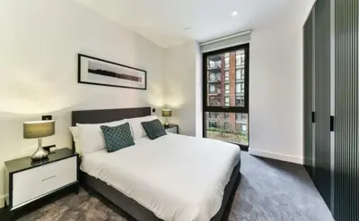 a bedroom with a white bed and a window at 2 bed Luxury apartment with balcony in Moffat