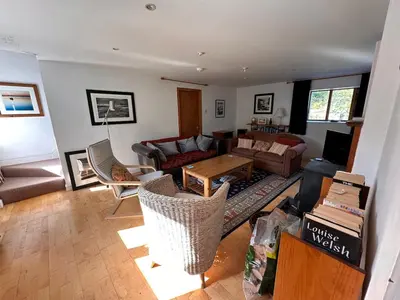 a living room with a couch and a table at Curlew Cottage - Peaceful Setting Stunning Views in Bruichladdich