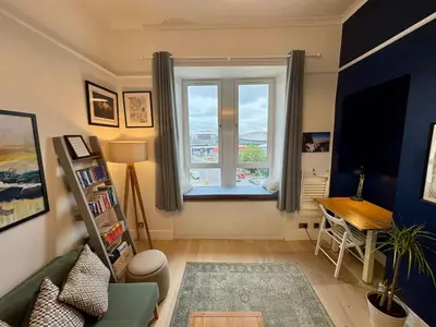 a living room with a window and a table at Warm upgraded top-floor flat in Finnieston in Glasgow