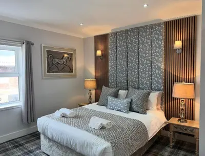 a bedroom with a bed with two towels on it at Belstane Manor in Carluke