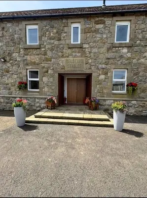 a stone building with the entrance to a stone house at Belstane Manor in Carluke