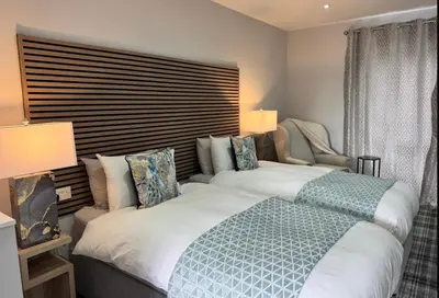 a bedroom with two beds and a window at Belstane Manor in Carluke