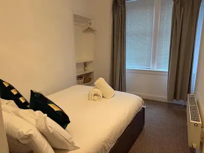 a bedroom with a bed with a towel on it at Stylish Glasgow Apartment in Whiteinch