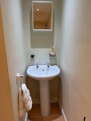a bathroom with a white sink and a mirror at Stylish Glasgow Apartment in Whiteinch