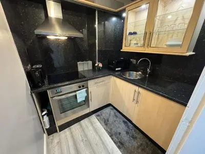 a small kitchen with a sink and a stove at Stylish Glasgow Apartment in Whiteinch