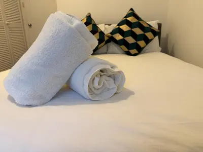 a rolled up towel sitting on top of a bed at Stylish Glasgow Apartment in Whiteinch