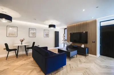 a living room with a couch and a tv and a table at Old Church Apartment 2 in Oban