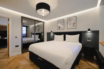a bedroom with a large bed with white sheets and pillows at Old Church Apartment 2 in Oban