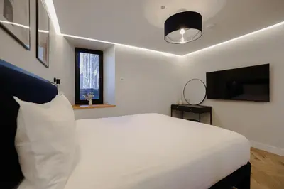 a bedroom with a white bed and a television at Old Church Apartment 2 in Oban