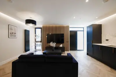 a living room with a black couch and a tv at Old Church Apartment 2 in Oban