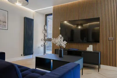 a living room with a blue couch and a tv at Old Church Apartment 2 in Oban