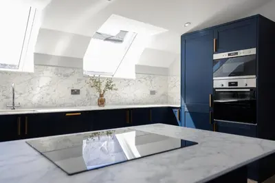 a kitchen with blue cabinets and a counter top at Old Church Apartment 4 in Oban